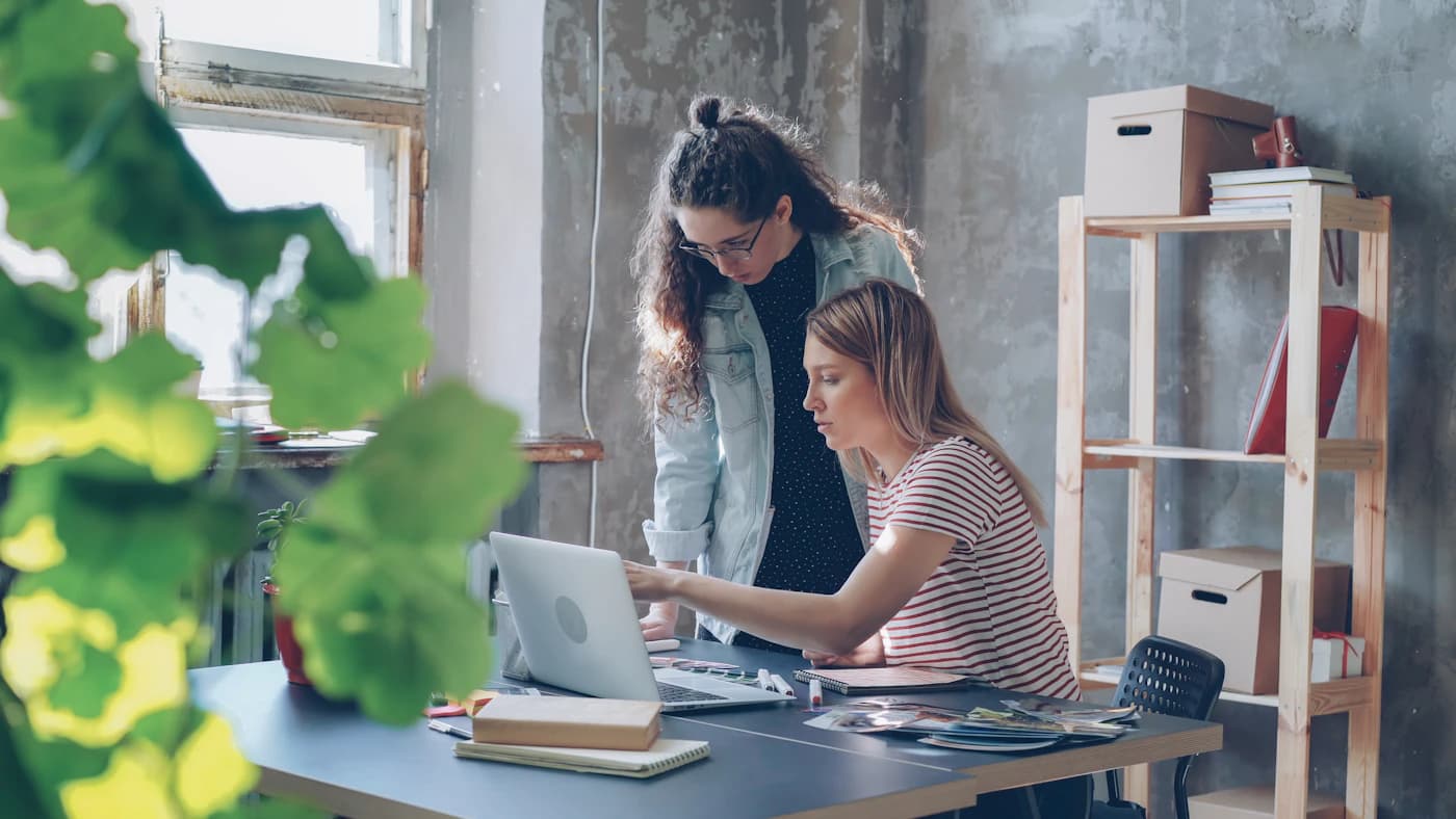 Colleagues collaborating with a laptop in an office